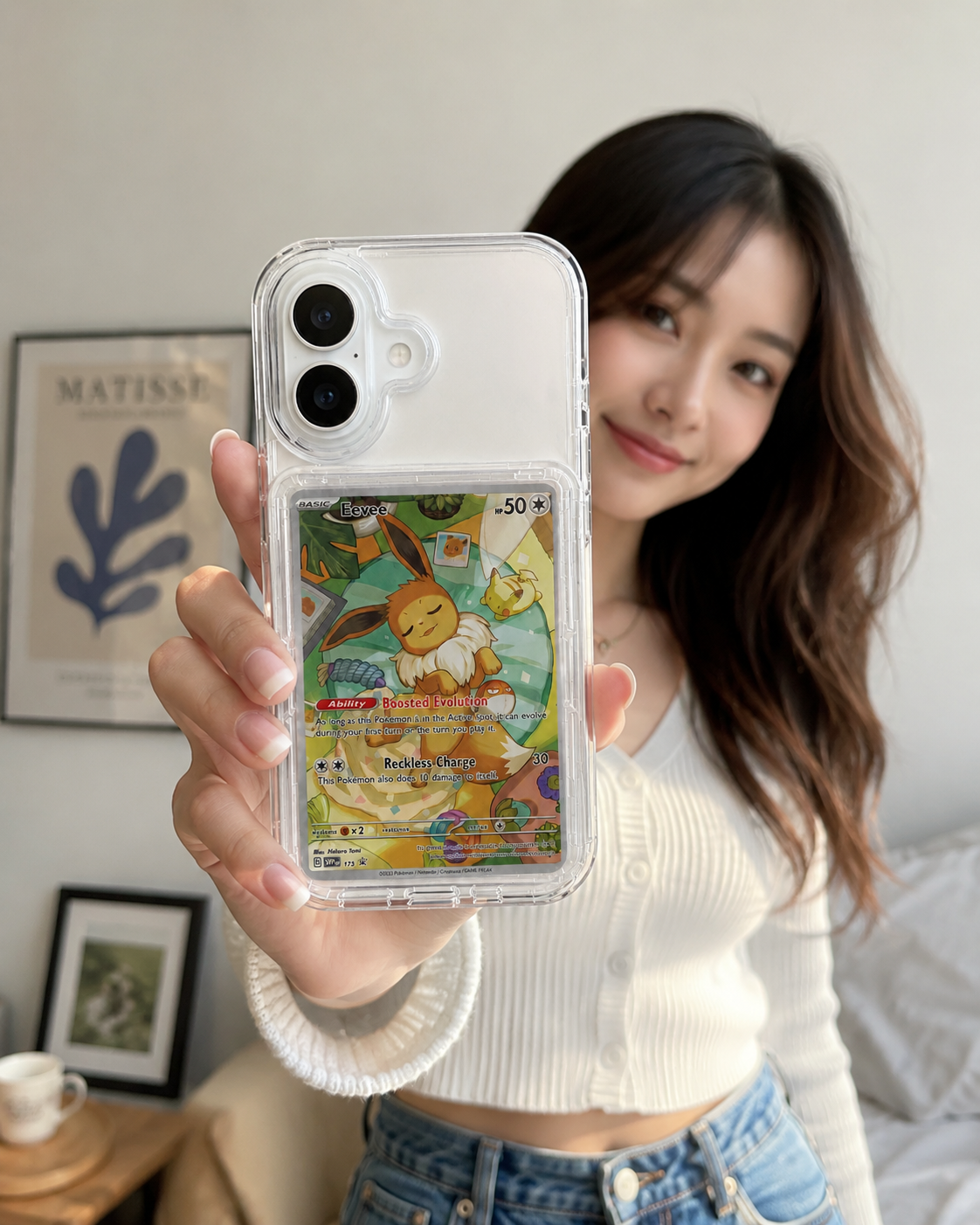 Person holding a phone case with a cartoon character on it, in a casual indoor setting.